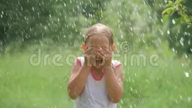 美丽的女孩在花园里泼水的肖像。 女孩完全<strong>湿透</strong>了，这`是非常炎热和快乐的一天。 概念